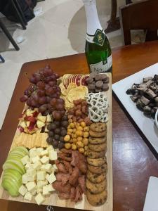 a cutting board with different types of food and a bottle of wine at T'zam Villa in Dipolog