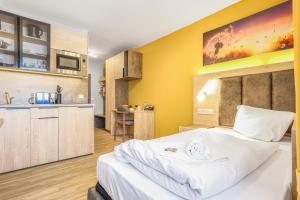 a bedroom with a large white bed and a kitchen at RENOVIERT XZLLENZ 50'' Smart TV, Parken, 24h digitaler Check In und Zugang, Küche in Oberasbach