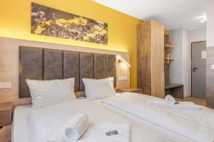 a bedroom with a large white bed with towels on it at RENOVIERT XZLLENZ 50'' Smart TV, Parken, 24h digitaler Check In und Zugang, Küche in Oberasbach