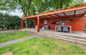a house with a deck with a table and chairs at Ermway Cottage in Erm