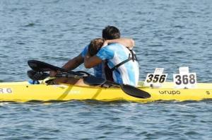 two men are hugging on a yellow boat in the water at Cabañas Ruidos de Agua in Choele Choel