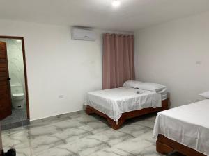 a small bedroom with two beds and a mirror at Brisas del mar 2c in Santa Cruz de Barahona