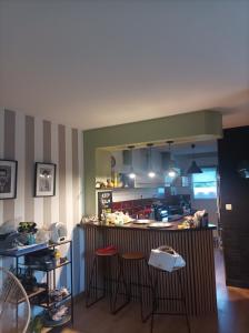 a kitchen with two bar stools and a counter at chambre double in Poitiers