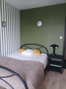 a bedroom with a bed and a clock on the wall at chambre double in Poitiers