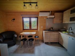 a kitchen with a table and chairs in a room at Domki Tepakówka in Wołkowyja