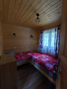 a small room with a bed in a cabin at Domki Tepakówka in Wołkowyja