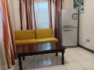 a living room with a couch and a refrigerator at Green Oasis Lodges in Harare