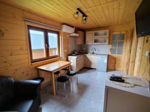 a kitchen with a table and chairs in a cabin at Domki Tepakówka in Wołkowyja