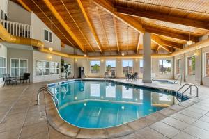 a swimming pool in a building with a large ceiling at Comfort Inn & Suites Near University of Wyoming in Laramie