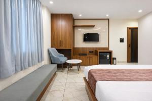 a hotel room with a bed and a tv at Planet Eco Stays - Near Mahakal Temple in Ujjain