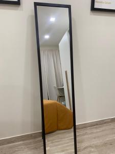 a mirror in a room with a yellow pillow and a chair at  