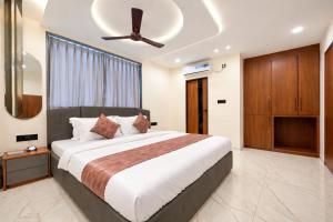 a bedroom with a large bed with a ceiling fan at Planet Eco Stays - Near Mahakal Temple in Ujjain