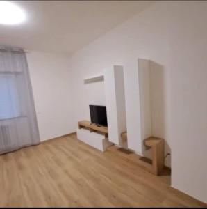 a living room with a tv and a white wall at Casa Margherita in Castelfidardo