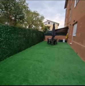 a backyard with a green lawn and an umbrella at Casa Margherita in Castelfidardo