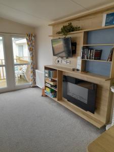 a living room with a tv and a book shelf at The retreat in Carlisle