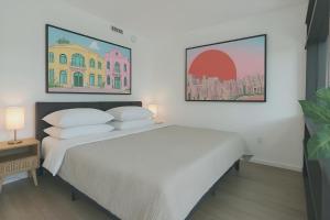 a bedroom with a large white bed with two pillows at Cadenza Miami - Luxury Residences in Miami