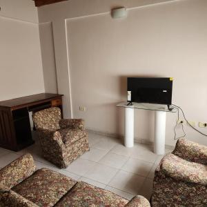 a living room with a tv and a table and chairs at Duplex Parking free in Estación Circunvalación