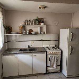 a white kitchen with a stove and a refrigerator at Duplex Parking free in Estación Circunvalación +8 photos