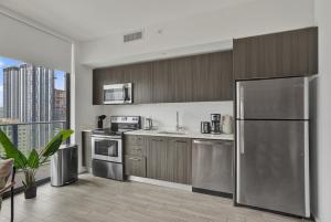 a kitchen with stainless steel appliances and a large window at Cadenza Miami - Luxury Residences in Miami