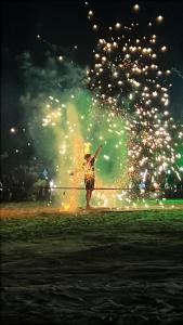 a person standing in a field with a fire hose at Aura Bluewave Beach House, Chenang in Pantai Cenang