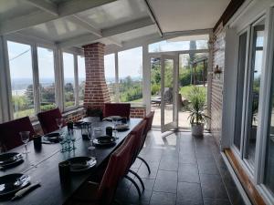 a dining room with a table and chairs and windows at House 33 in Stari Slankamen