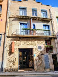 a building with a balcony on top of it at Hostal Agrobotiga 7 de Ribera in Móra d'Ebre