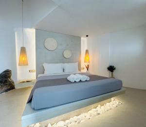 a bedroom with a large bed with rocks around it at Kaleidoscope Cave Houses in Oia +63 photos
