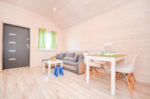 a living room with a table and a couch at Domki Agnes in Darłowo