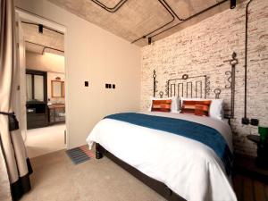 a bedroom with a brick wall and a large bed at Maximo Mexico Roma in Mexico City