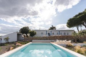 a house with a swimming pool in front of a building at Monte da Torre in Tavira