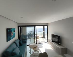 a living room with a blue couch and a television at Apartamentos Arinaga Ocean View in Arinaga