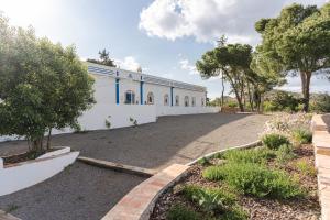 a large white building with trees in front of it at Monte da Torre in Tavira
