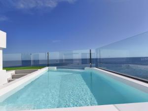 a swimming pool with a view of the water at Apartamentos Arinaga Ocean View in Arinaga