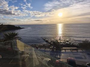 a view of the ocean at sunset from a balcony at Apartamentos Arinaga Ocean View in Arinaga
