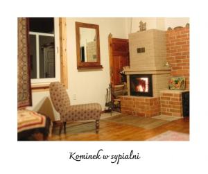 a living room with a brick fireplace and a chair at Willa Witówka in Olszówka +27 photos