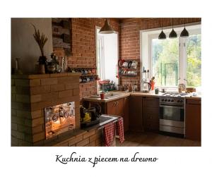 a kitchen with a brick wall and a stove at Willa Witówka in Olszówka