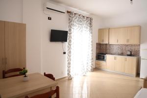a kitchen with a table and a window and a table and a kitchen at Vila Lori in Ksamil