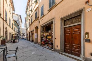 an empty street with a building with a wooden door at Romantico appartamento nel centro storico in Cortona +5 photos