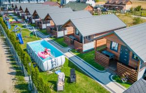 an aerial view of a resort with a pool and a house at Domki Agnes in Darłowo