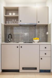 a kitchen with white cabinets and a sink at Anna Studio in Amoudara Herakliou +78 photos