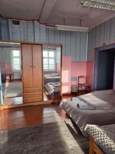a bedroom with two beds and a mirror at Rozulas skola in Rozula