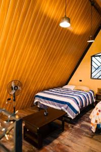 a bedroom with a bed and a table in a room at Casa Monte Bello- Cabaña privada in Huehuetenango