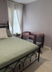 a bedroom with a bed and a chair and a window at Vacation QJR in Cutler Bay