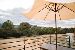 a table with an umbrella on a balcony at Casa Monte Bello- Cabaña privada in Huehuetenango