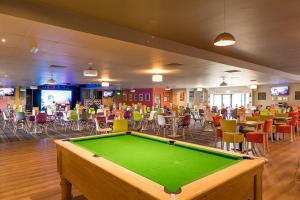 a pool table in a room with tables and chairs at My Spacious Kentish 3-Room Van in Birchington