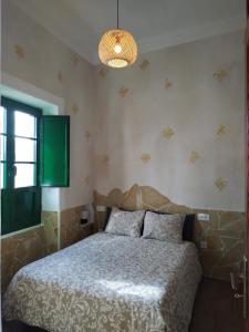 a bedroom with a bed and a chandelier at Casa MaCló Tranquilidad y autenticidad in Máguez