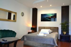 a bedroom with a bed and a table and a chair at Apartament Piast w Rynku in Nysa