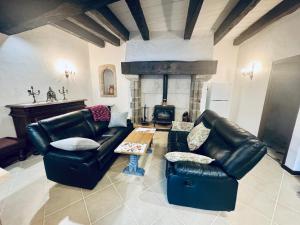 a living room with leather furniture and a fireplace at Maison du Roy/ Upper Cambers in Saint-Antonin
