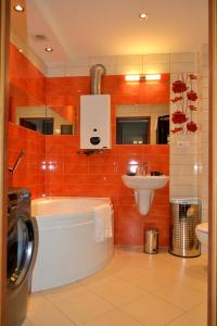 a bathroom with a tub and a sink and a washing machine at Apartament Piast w Rynku in Nysa +2 photos
