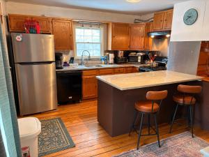 a kitchen with a stainless steel refrigerator and wooden cabinets at My Valhalla Farm in Oakland
